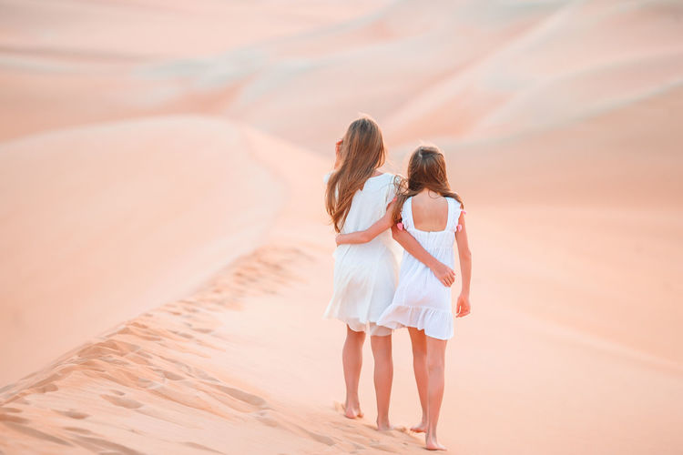 Rear view of women walking in desert