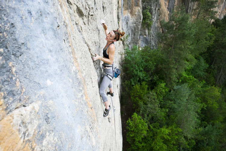 High angle view of woman climbing rock