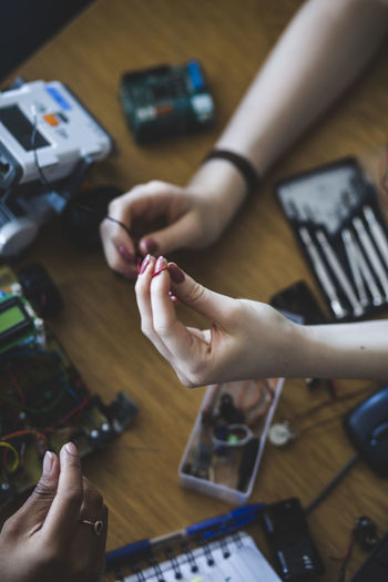 High angle view of female students preparing science project at desk in high school classroom