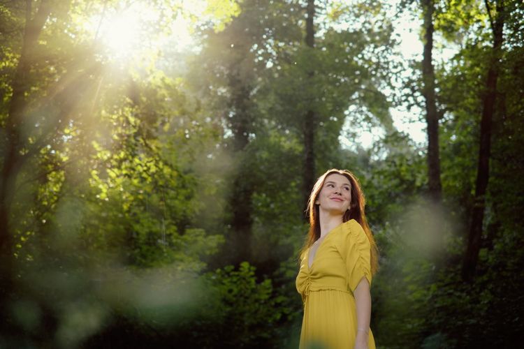 Smiling woman standing in forest