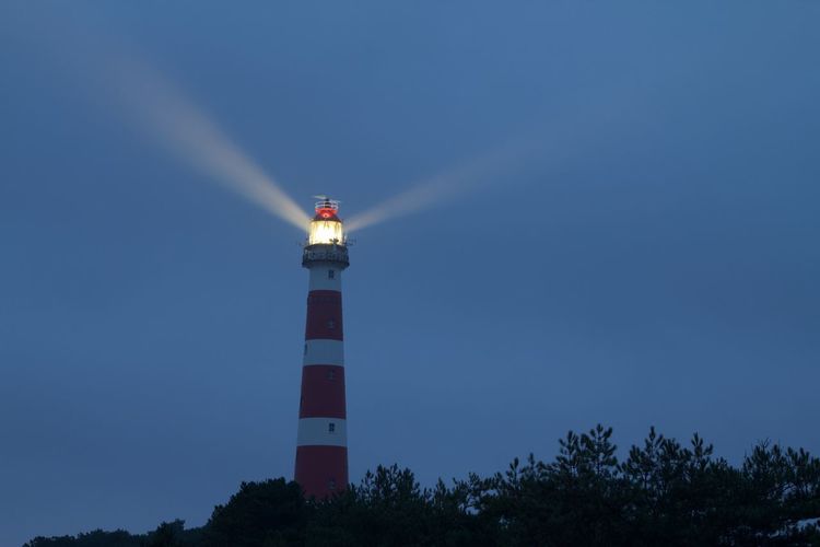 Low angle view of lighthouse against sky at night