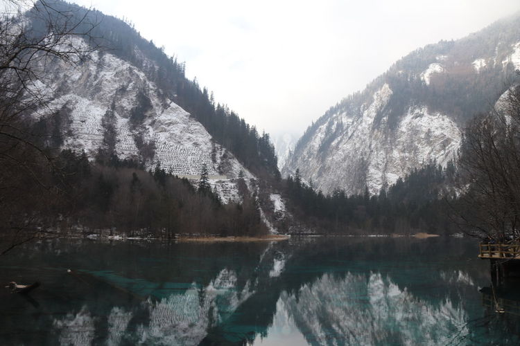 Beatiful landscape of a lake between mountains with reflexion of trees in the water in jiuzhaigou 