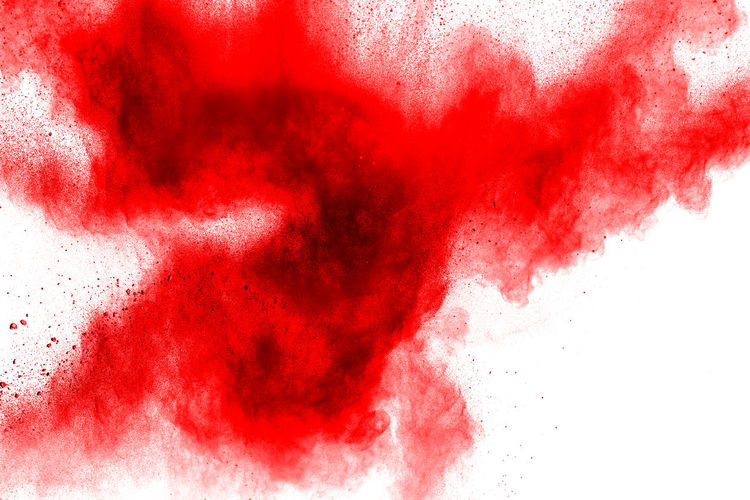 Defocused image of red powder paints against white background