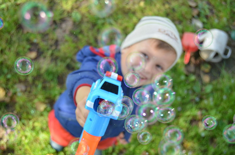 High angle portrait of boy playing with squirt gun