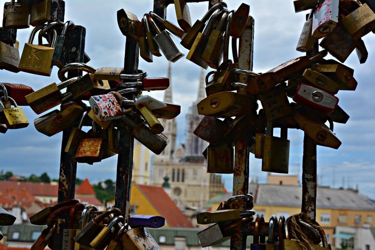 Padlocks attached on railing with historic building in background