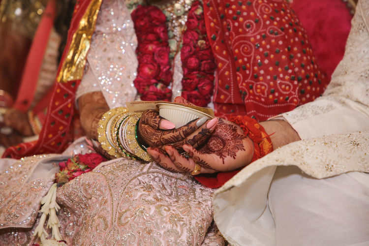 Bride and groom holding hands performing rituals of indian wedding