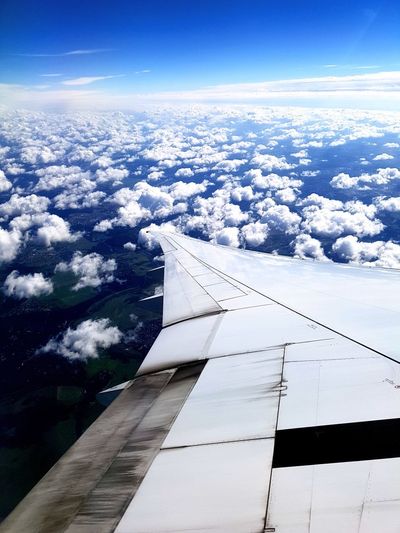 Aerial view of airplane wing against blue sky