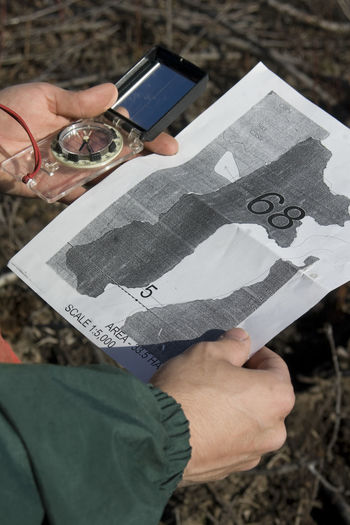 Cropped hands holding map and navigational compass