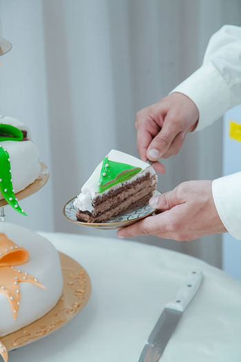 Cropped image of person holding cake in plate