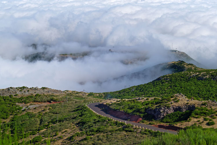 Road on the mountain peak against dense clouds