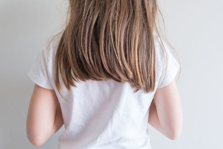 Rear view of woman standing against white background
