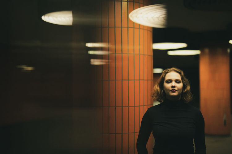 Portrait of woman standing in illuminated garage