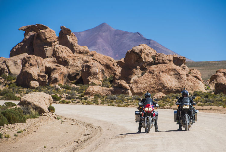 Two friends riding touring motorcycle's on dusty road in bolivia