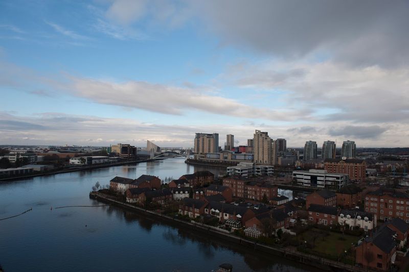 High angle view of river by buildings in city against sky