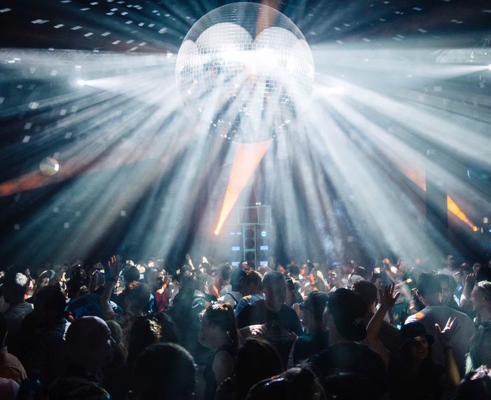 Illuminated disco ball over crowd at nightclub