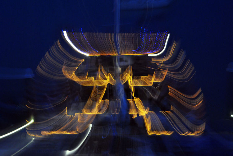 Close-up of illuminated light trails against sky at night