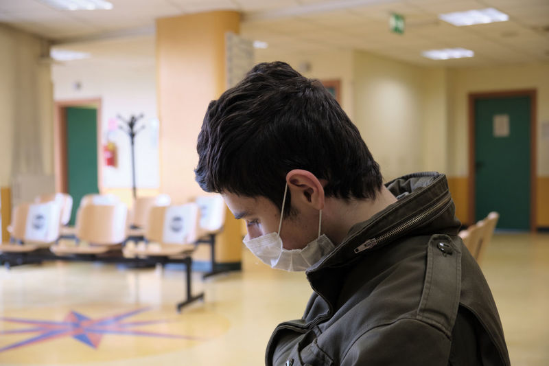 Caucasian boy wearing covid19 mask is waiting for hospital exams