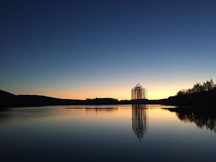 Reflection of art in lake at dawn