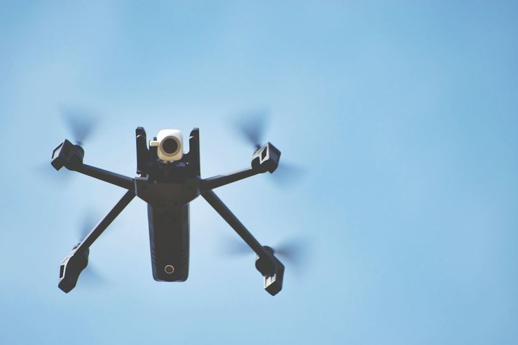 Low angle view of flying drone against sky