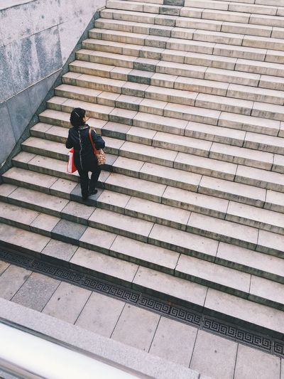 High angle view woman moving up on staircase