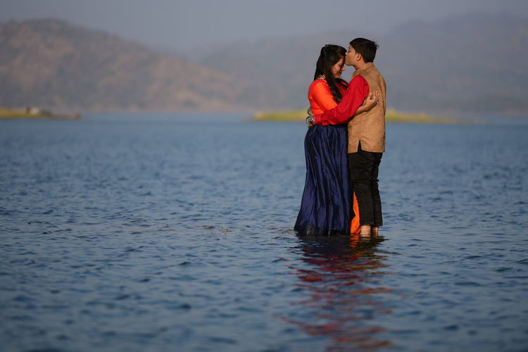 View of couple standing in water
