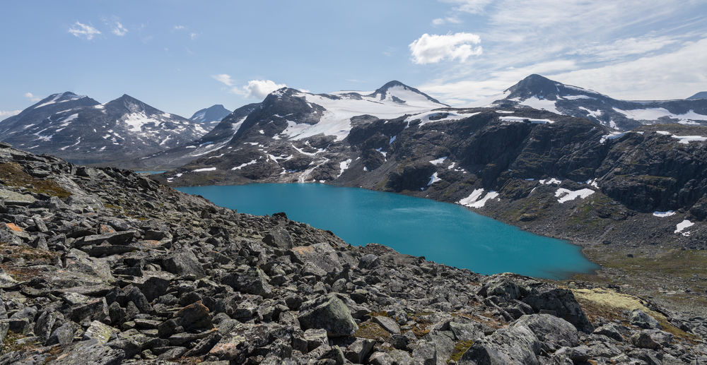 Glacial lake near leirdalen in jotunheimen national park against rough mountain range with glaciers