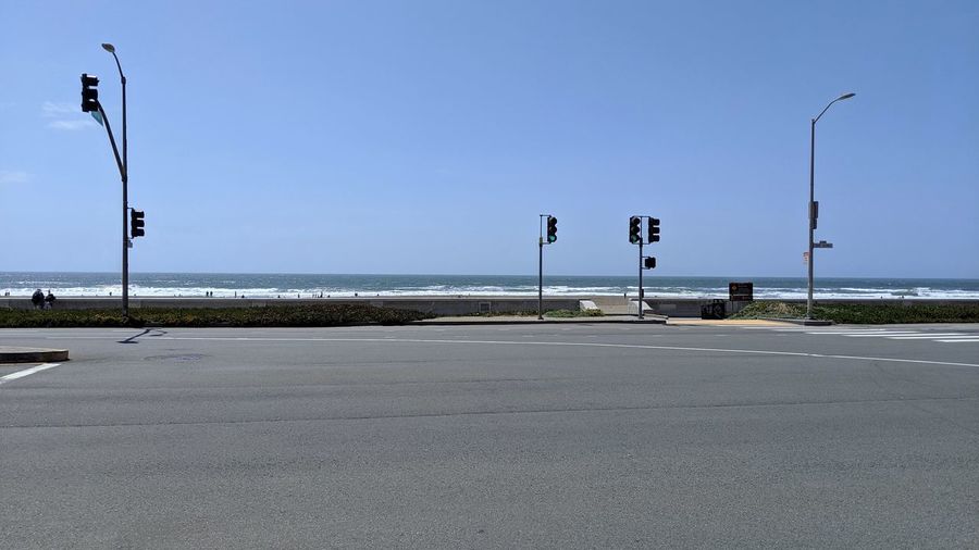 Road by sea against clear sky