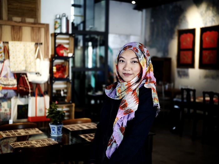 Portrait of smiling young woman standing in restaurant