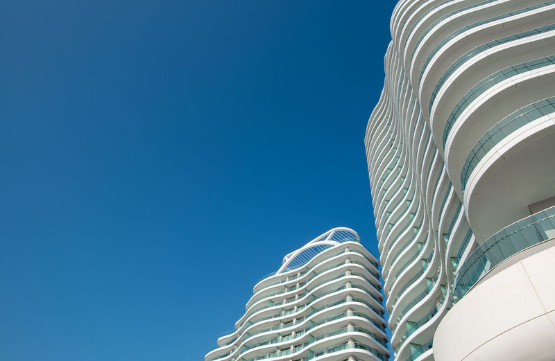 Low angle view of modern building against clear blue sky