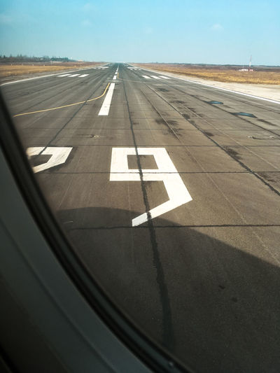 Airplane on airport runway against sky