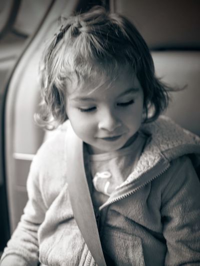Close-up of girl looking down while sitting in car