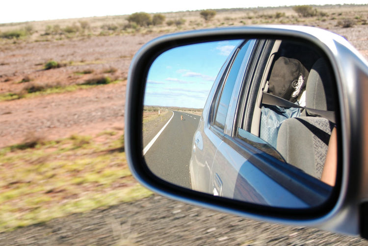 Close-up of road reflecting on side-view mirror