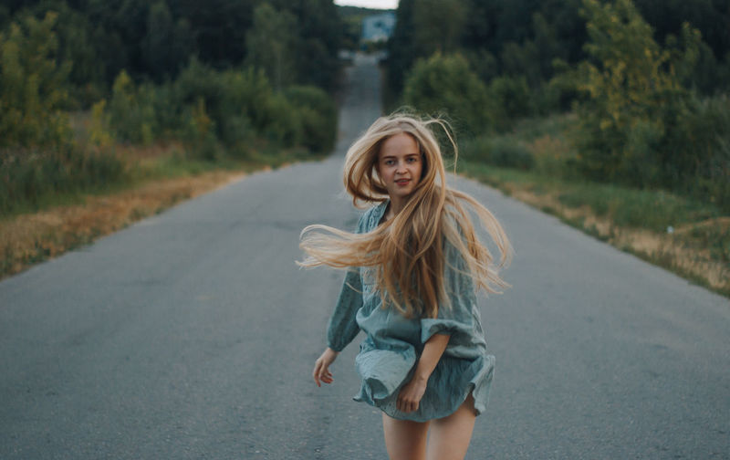 Portrait of smiling young woman on road