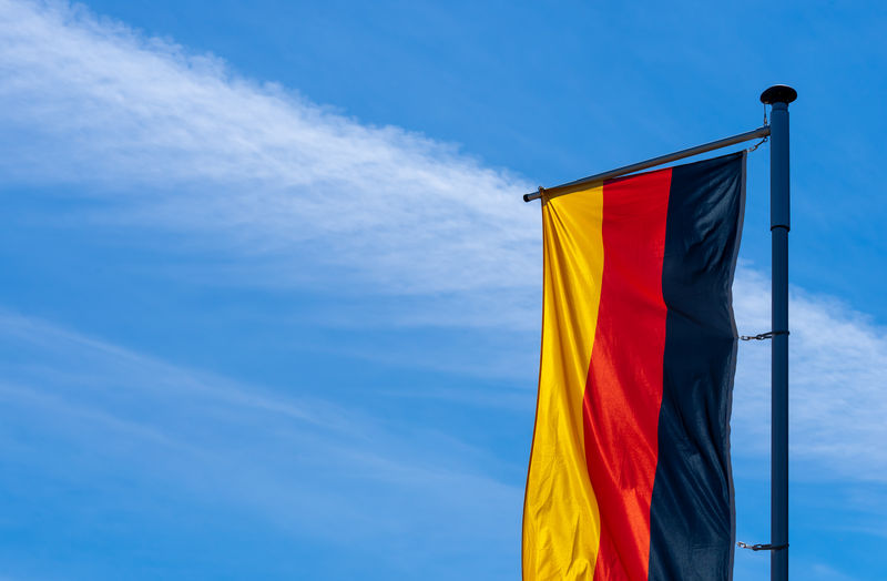 Low angle view of flag against blue sky