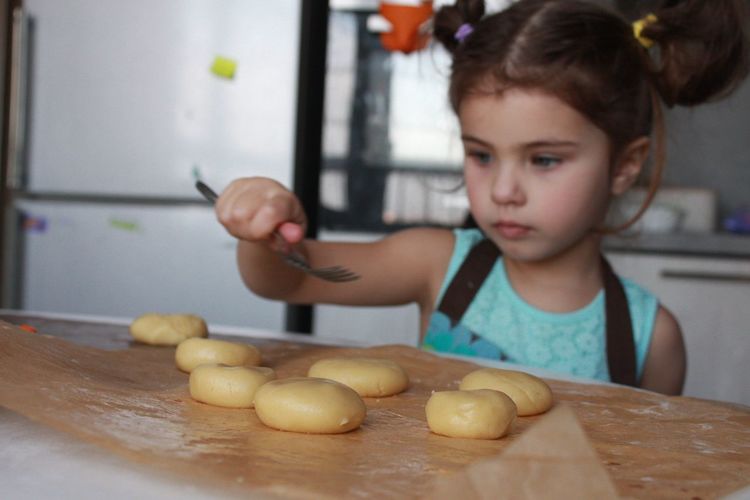 Clisr-up cute girl making traditional cookies in the domestic  kitchen