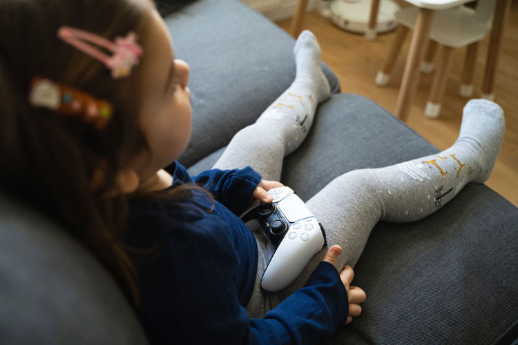 High angle view of girl playing video game at home