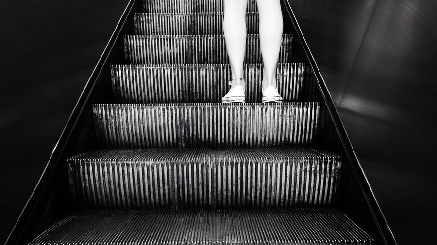 Low angle view of woman standing on escalator