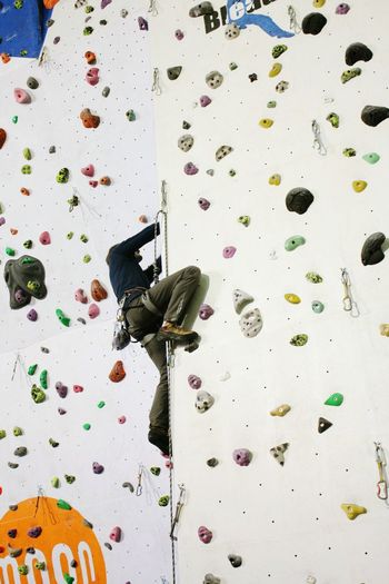 Low angle view of man climbing artificial wall