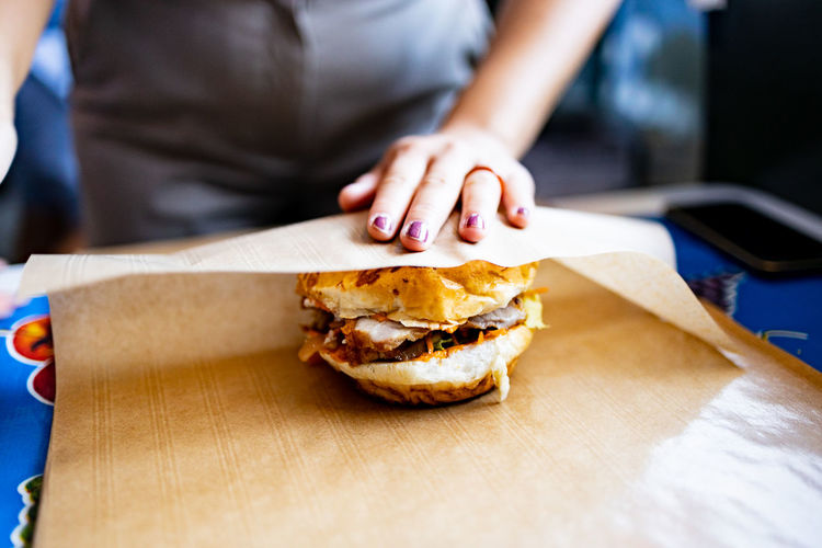 Midsection of man holding burger