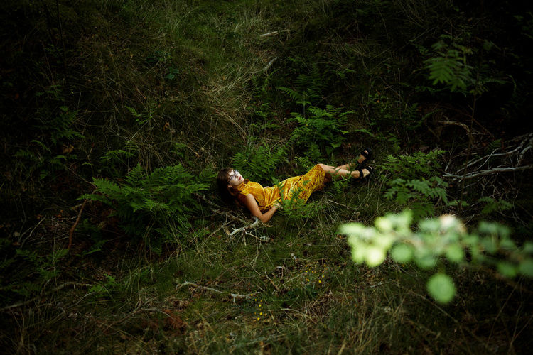 High angel view of woman lying on plants