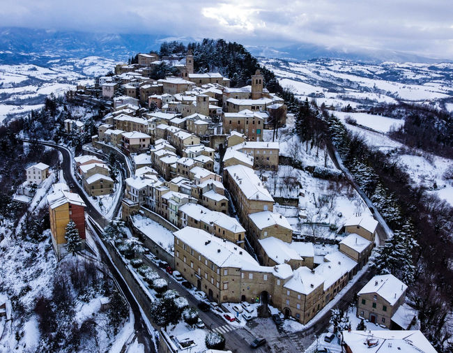 High angle view of snow covered houses and buildings in city