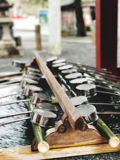 Close-up of ladles over water at temple