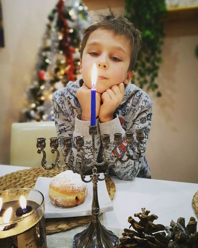 Portrait of young boy with menorah at the beginning of hanukkah. 