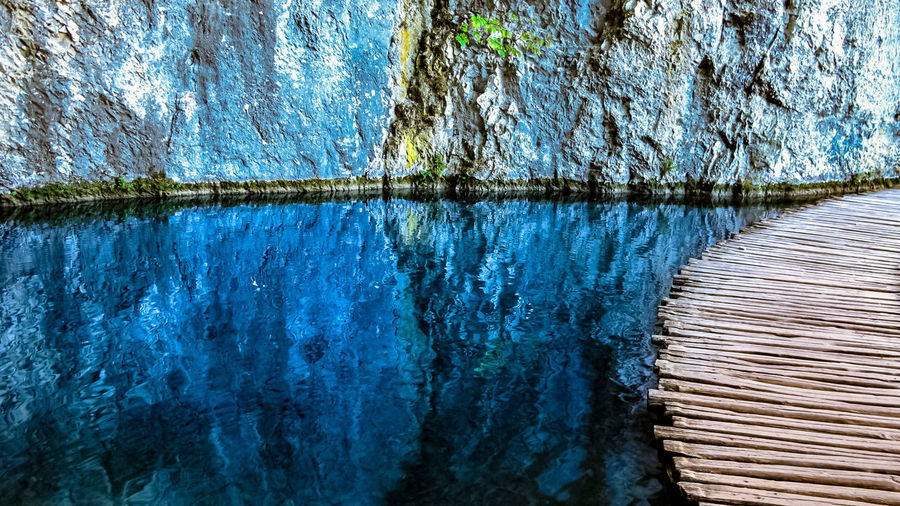 A wooden trail deck with crystal clear water by it, plitvice national park, croatia.