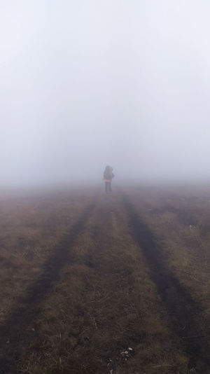Man on field against sky during foggy weather