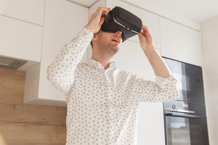 Man wearing virtual reality simulator at home