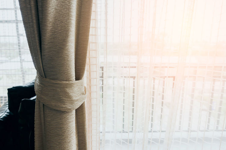 Close-up of curtains hanging by window at home