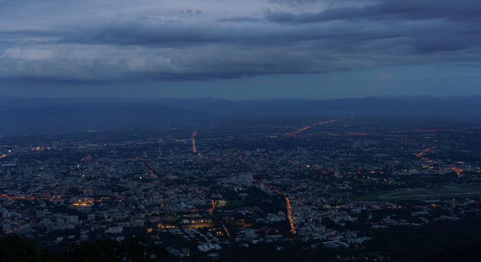 Aerial view of illuminated city against sky at dusk