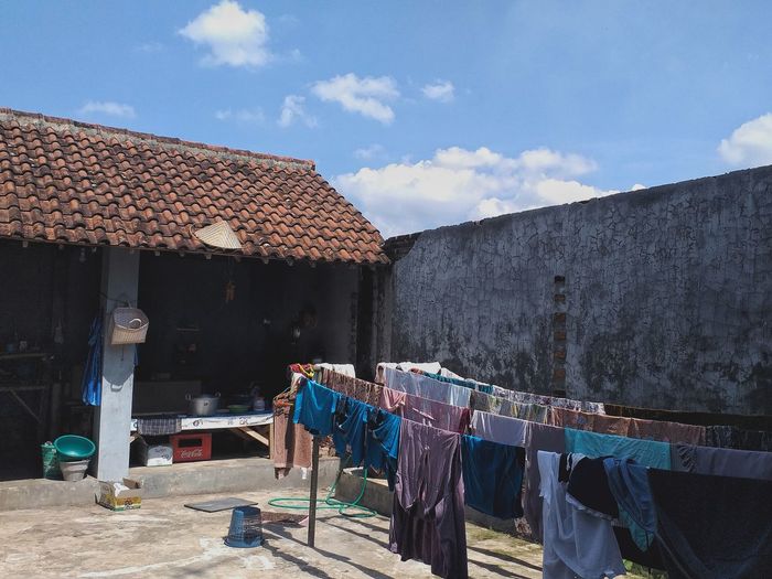 Clothes drying on roof outside building against sky