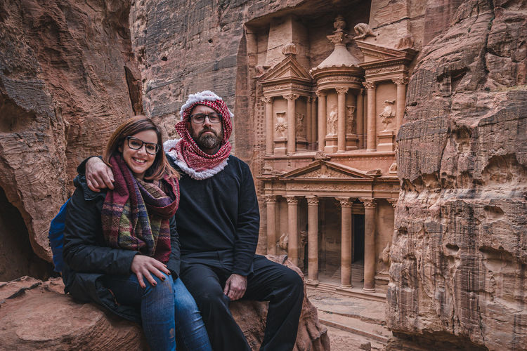 Portrait of couple sitting on rock formation